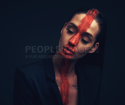 Buy stock photo Studio shot of a young woman posing with paint on her face on a black background