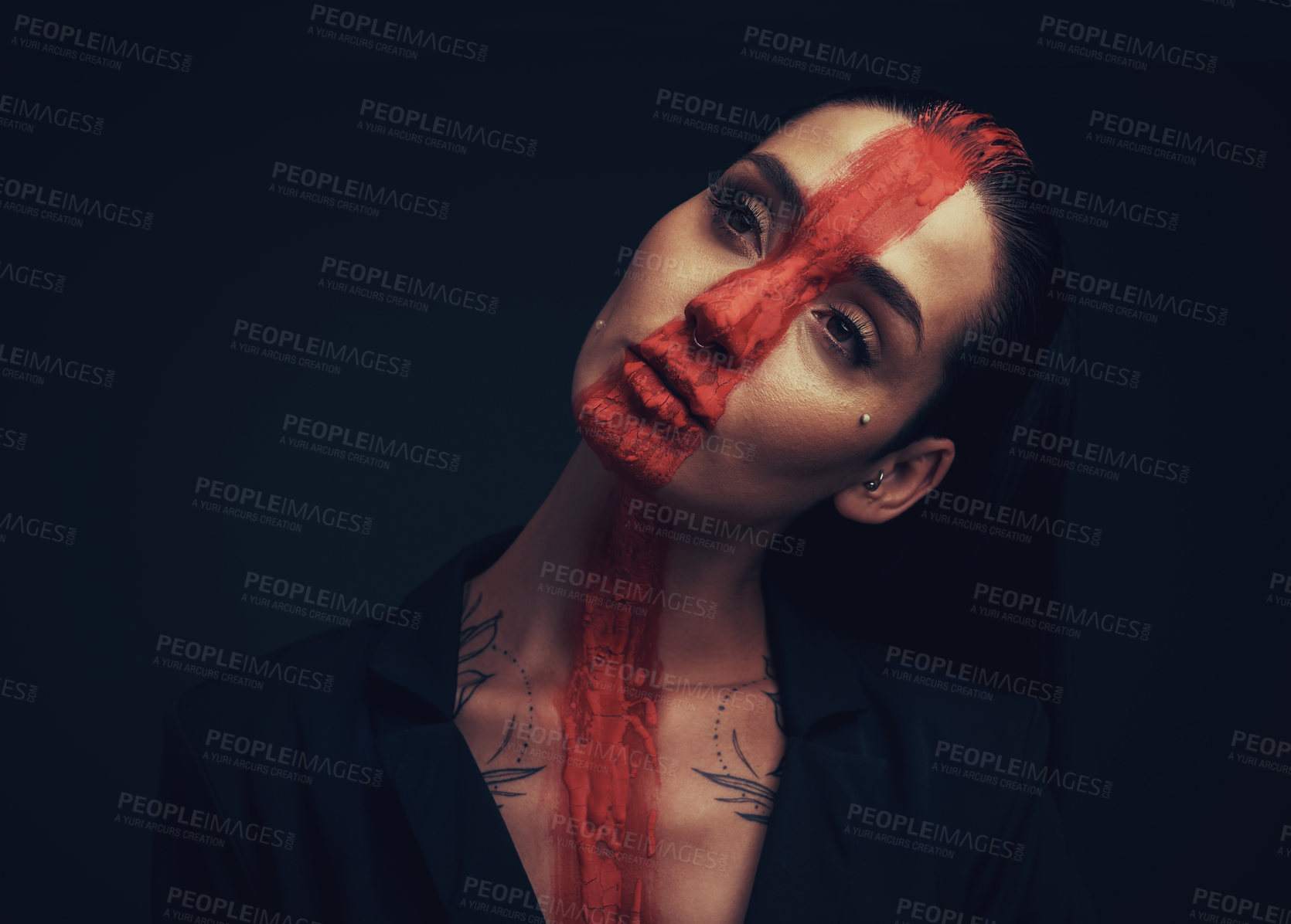 Buy stock photo Studio shot of a young woman posing with paint on her face on a black background