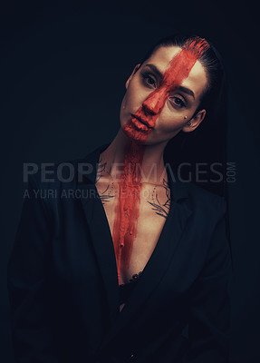 Buy stock photo Studio shot of a young woman posing with paint on her face on a black background