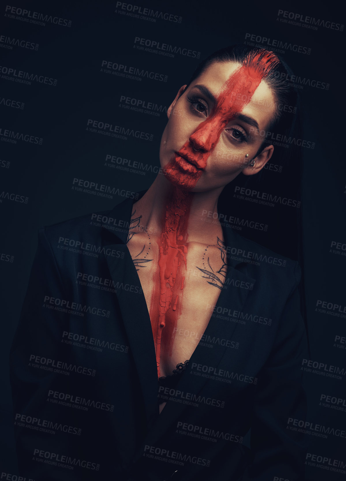 Buy stock photo Studio shot of a young woman posing with paint on her face on a black background