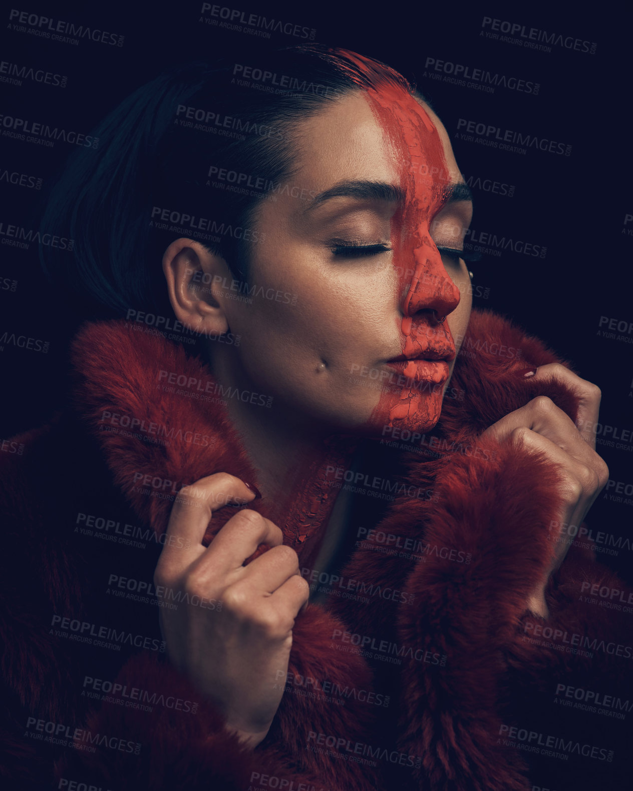 Buy stock photo Studio shot of a young woman posing with paint on her face on a black background