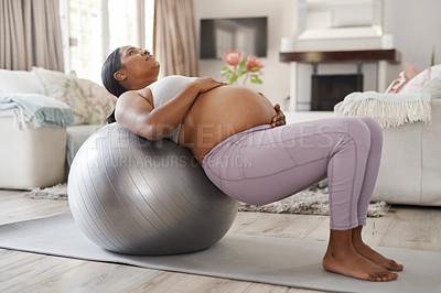 Buy stock photo Shot of a beautiful young pregnant woman exercising at home