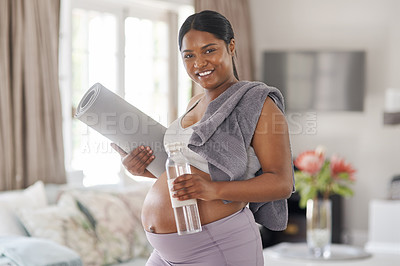 Buy stock photo Shot of a pregnant woman holding a water bottle and yoga mat at home