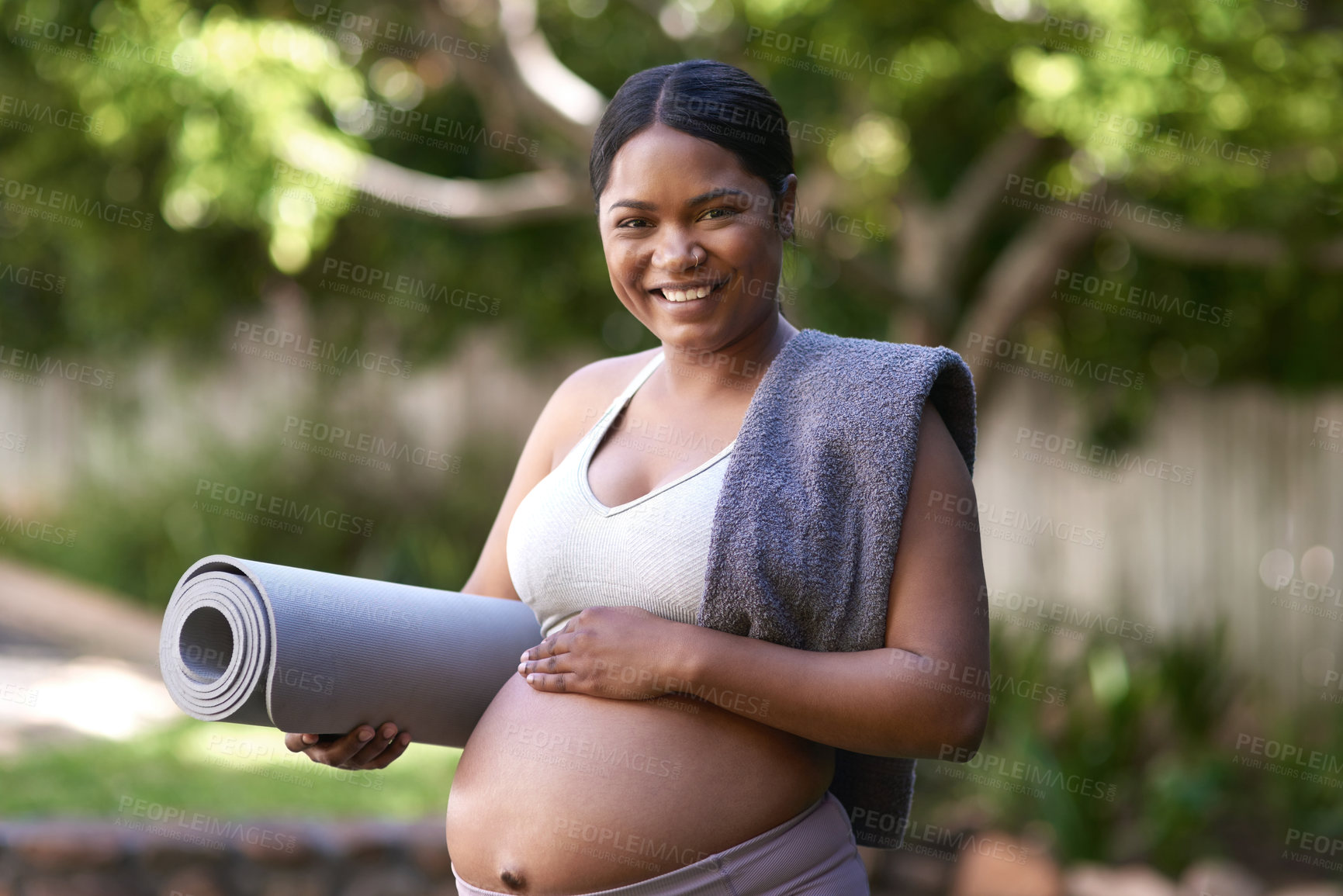 Buy stock photo Shot of a beautiful young pregnant woman standing outside with her yoga mat