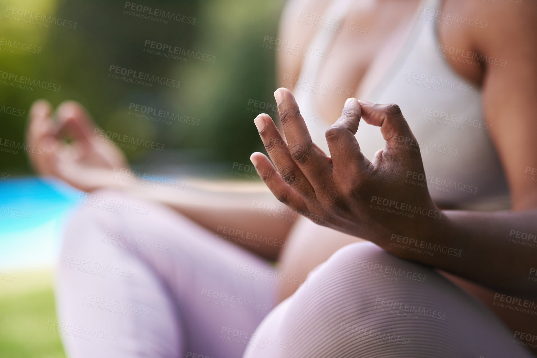 Buy stock photo Cropped shot of a pregnant woman meditating while sitting outside