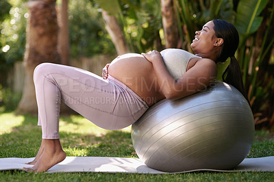 Buy stock photo Shot of a pregnant woman working out with a stability ball outside