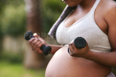 Buy stock photo Cropped shot of a pregnant woman working out with dumbbells