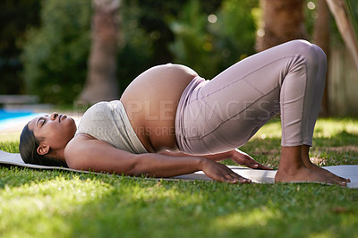 Buy stock photo Shot of a pregnant woman doing yoga outside