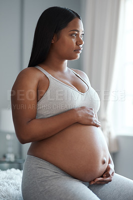 Buy stock photo Shot of a pregnant woman looking thoughtful at home