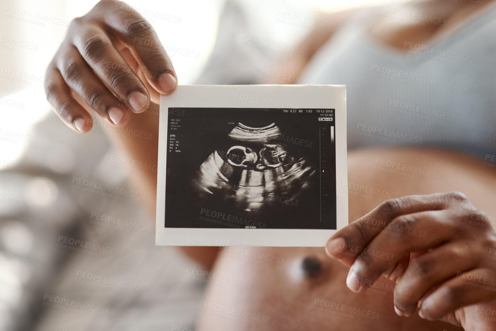 Buy stock photo Closeup shot of an unrecognisable woman holding a sonogram at home