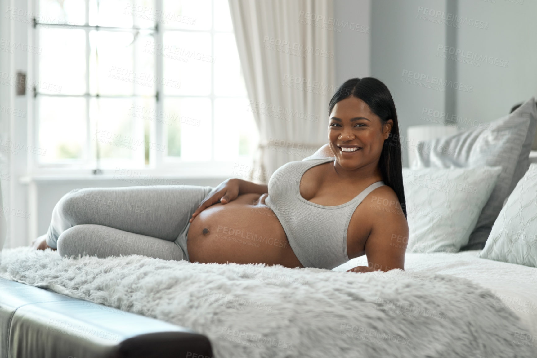 Buy stock photo Portrait of a pregnant woman lying on a bed at home