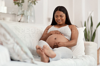 Buy stock photo Shot of a pregnant woman relaxing on a sofa at home