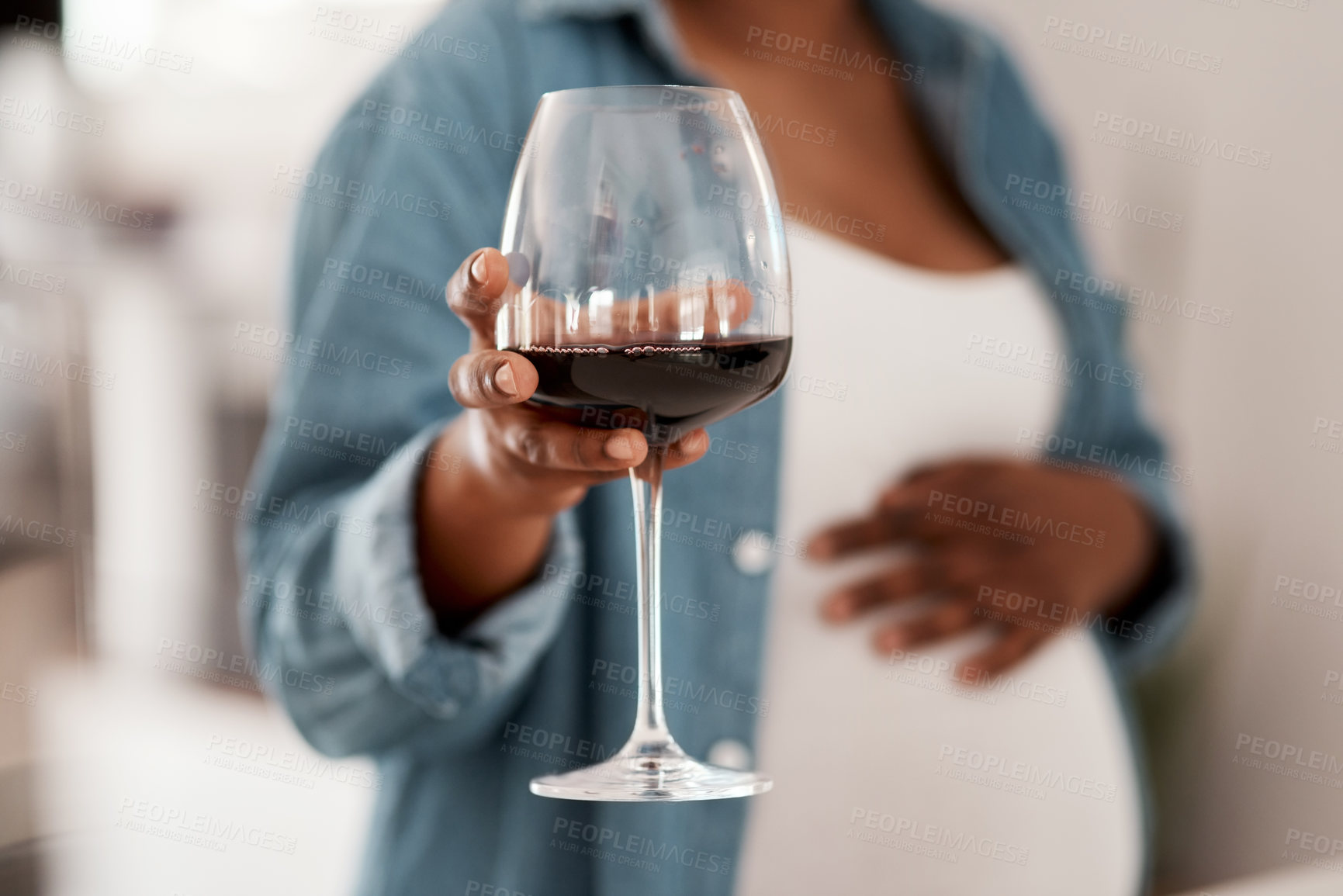 Buy stock photo Closeup shot of a pregnant woman holding a glass of red wine at home