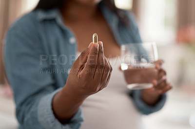 Buy stock photo Closeup shot of a pregnant woman taking medication at home