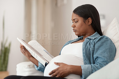 Buy stock photo Shot of a pregnant woman reading a book at home