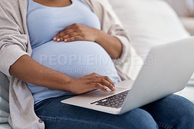 Buy stock photo Cropped shot of a pregnant woman using her laptop while sitting at home