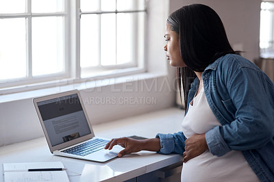Buy stock photo Shot of a pregnant woman using her laptop while sitting at home