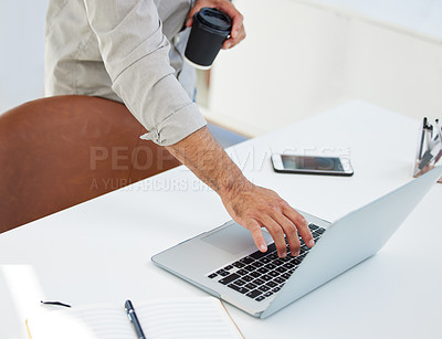 Buy stock photo Shot of a unreconizable man using his laptop at work in a modern office