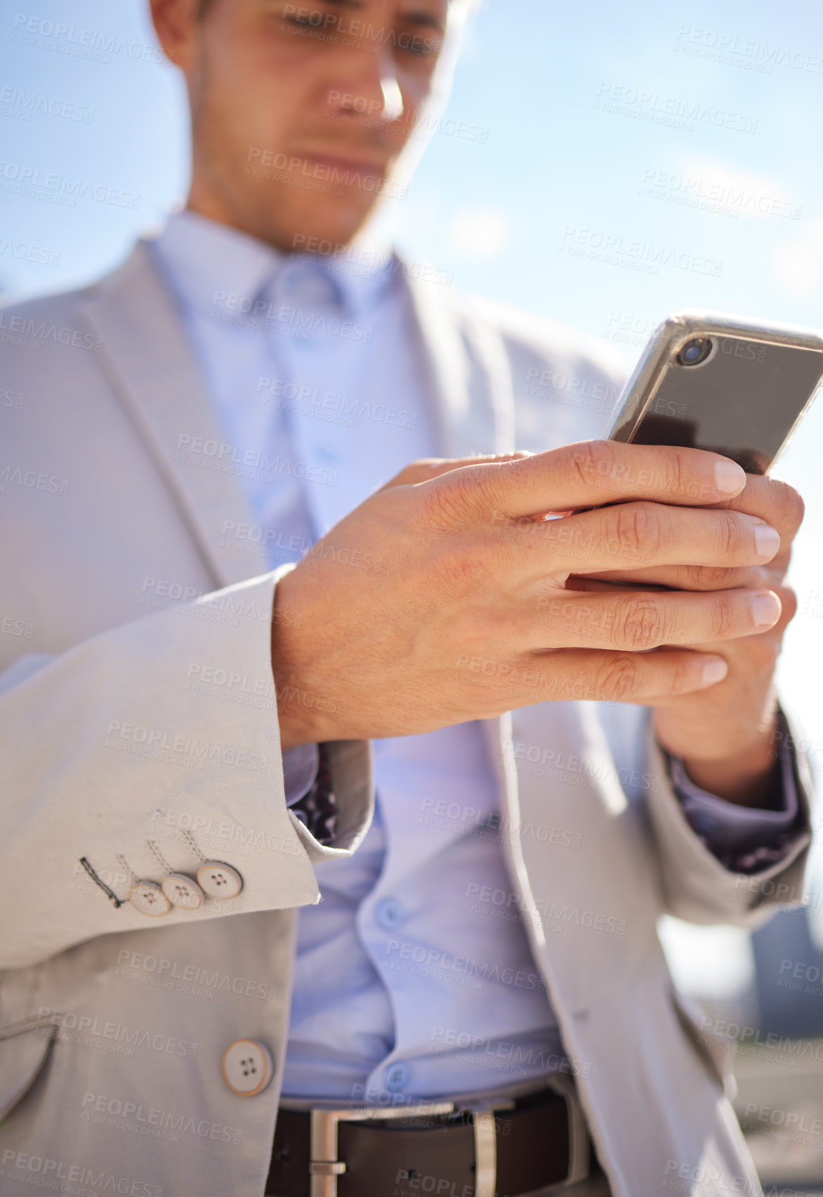 Buy stock photo Shot of a young businessman using a cellphone in the city