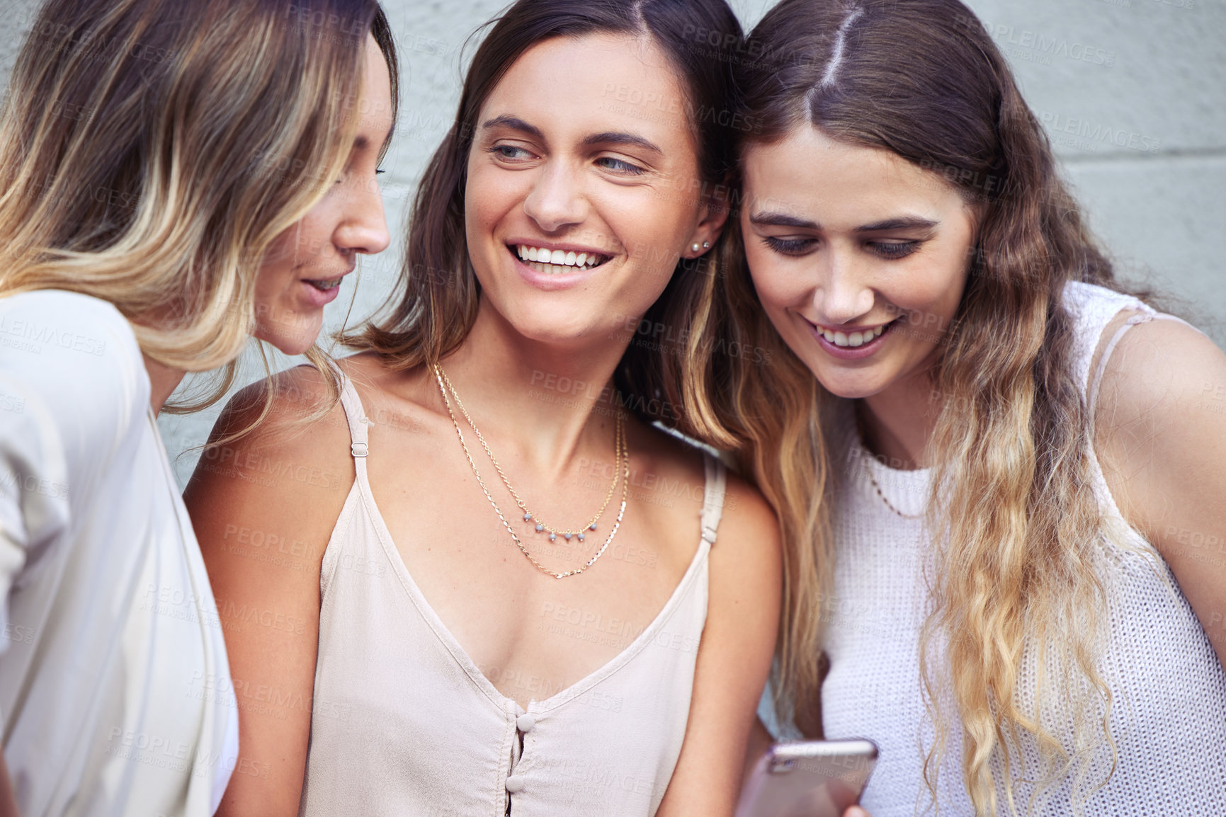 Buy stock photo Shot of young female friends using a smartphone