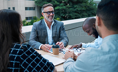 Buy stock photo Shot of a mature businessman having a meeting with his colleagues on the balcony of an office