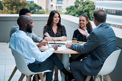 Buy stock photo Shot of a group of businesspeople having a meeting together on the balcony of an office