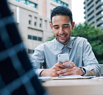 Buy stock photo Shot of a young businessman using a cellphone during a meeting on the balcony of an office