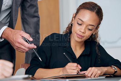 Buy stock photo Shot of a young businesswoman taking notes in a modern office