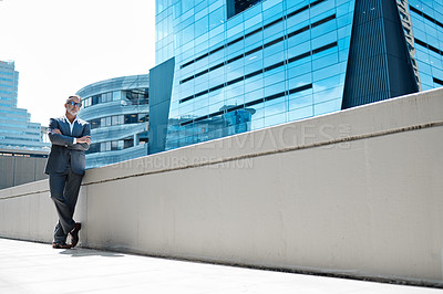 Buy stock photo Shot of a mature businessman standing with his arms crossed in front of a building in the city