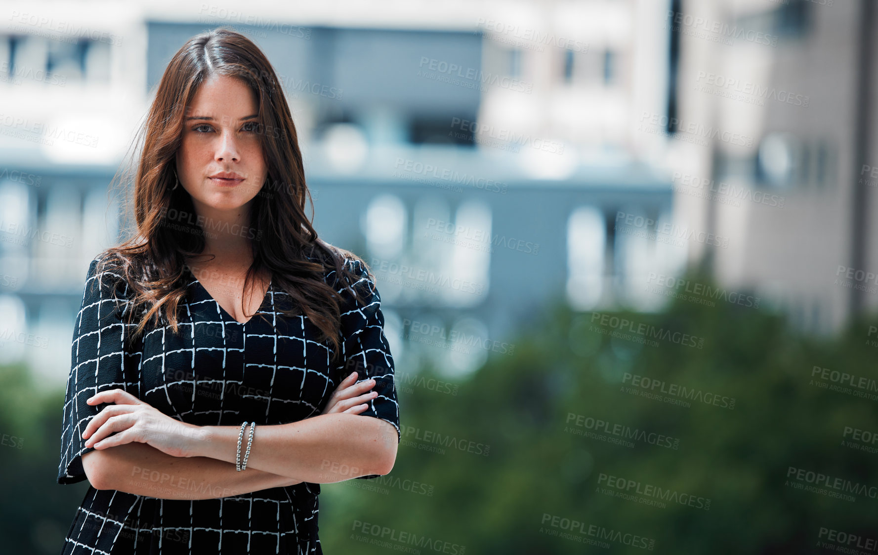 Buy stock photo Shot of a young businesswoman posing against an urban background