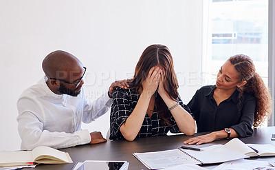 Buy stock photo Shot of a young businesswoman in distress being comforted by her coworkers