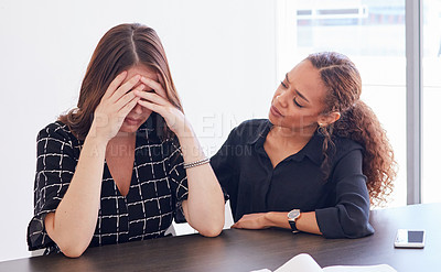Buy stock photo Shot of a young businesswoman in distress being comforted by her coworker