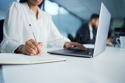 Buy stock photo Shot of a businesswoman taking notes while working in her office