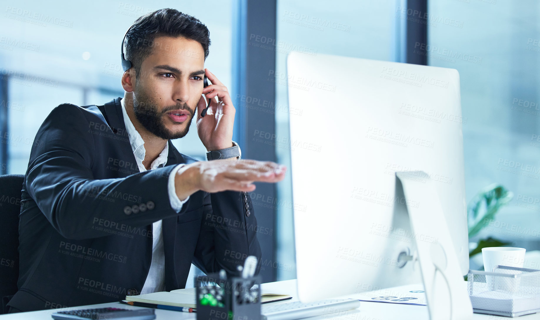 Buy stock photo Shot of a young businessman working in a call center