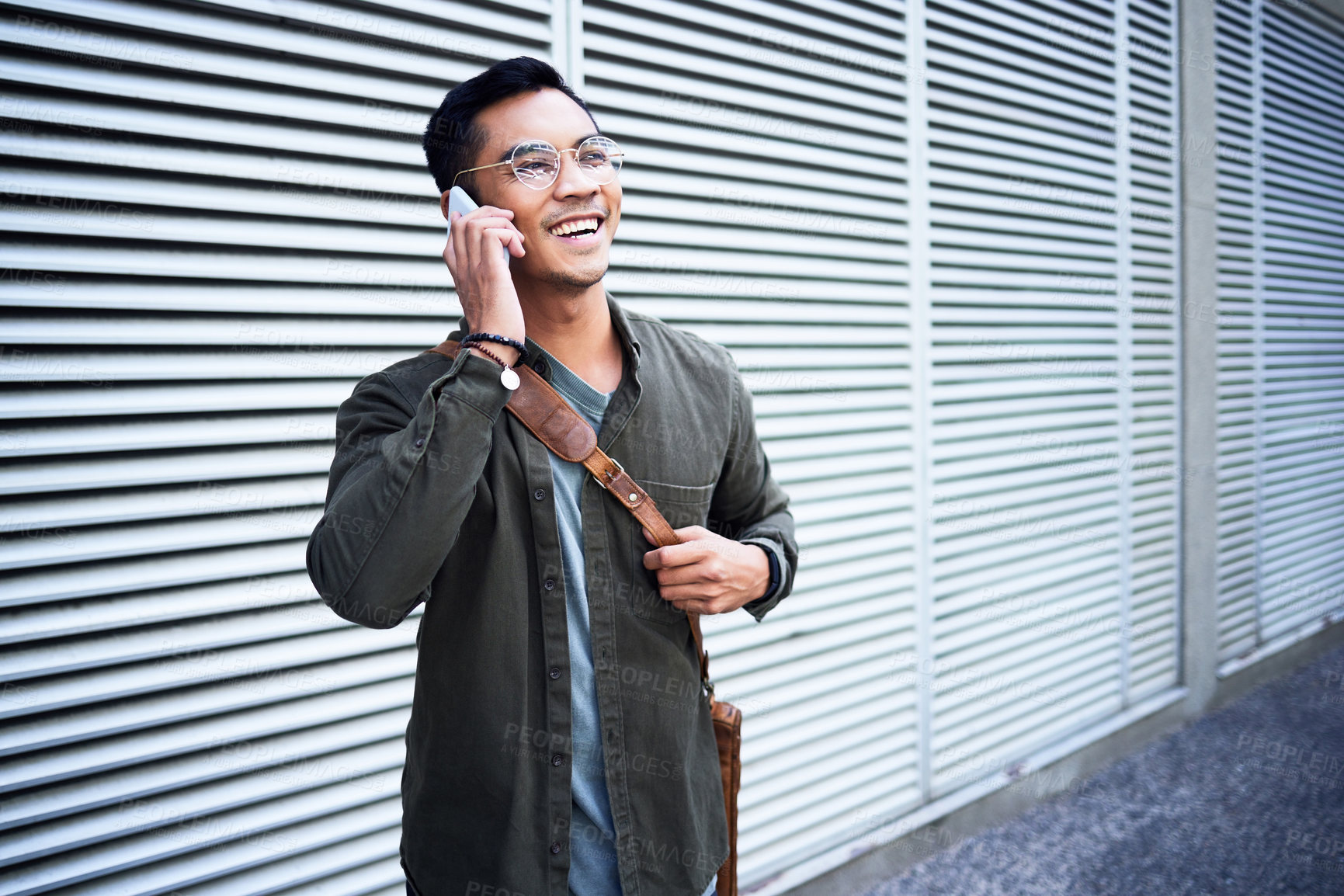 Buy stock photo Asian man, glasses and phone call outdoor with talking for virtual consultation, leather bag and conversation. Happy male person, discussion on mobile in city with contact, 5g network and good news