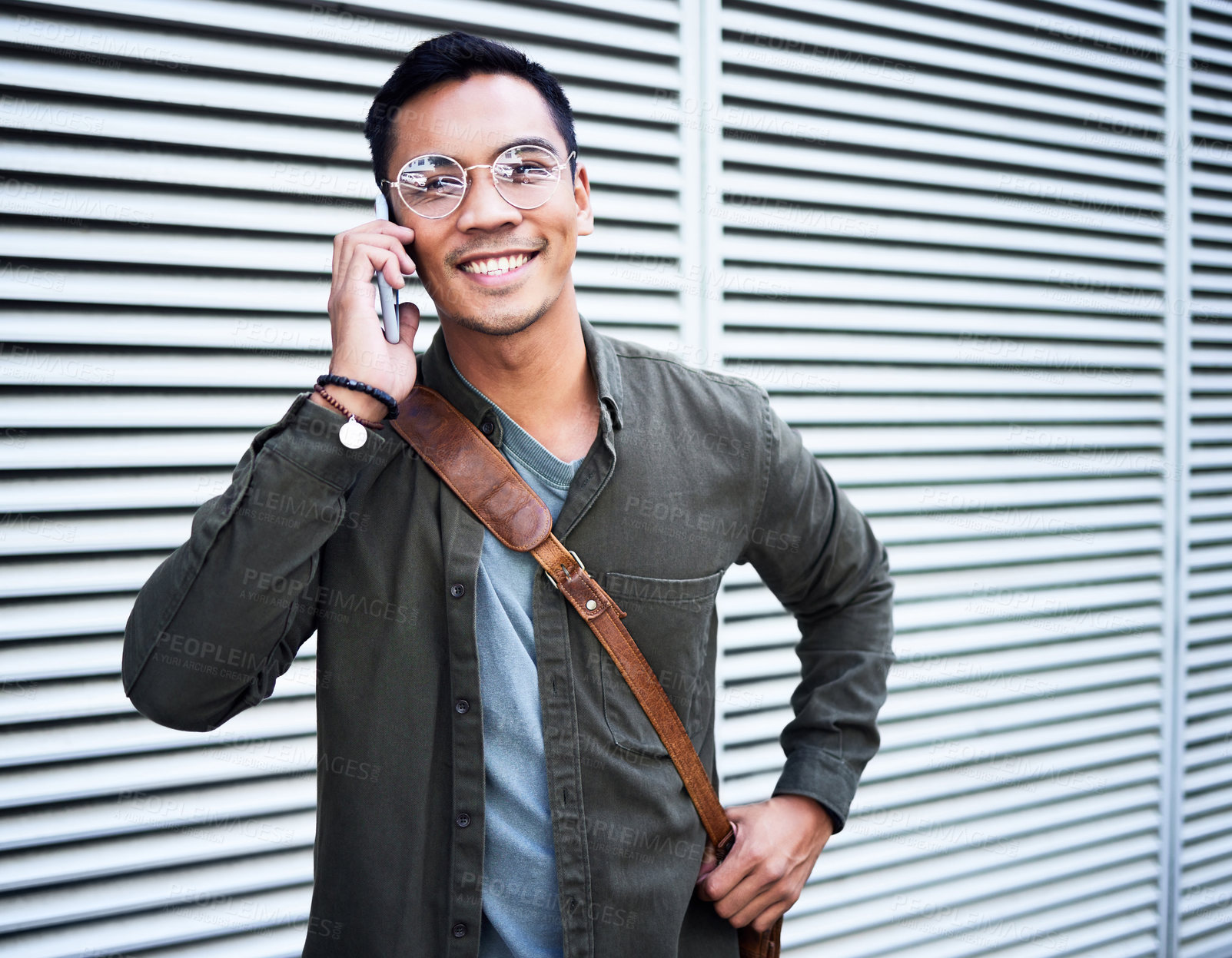 Buy stock photo Shot of a young man using a phone in the city