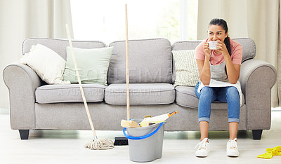 Buy stock photo Shot of a woman taking a coffee break while cleaning at home