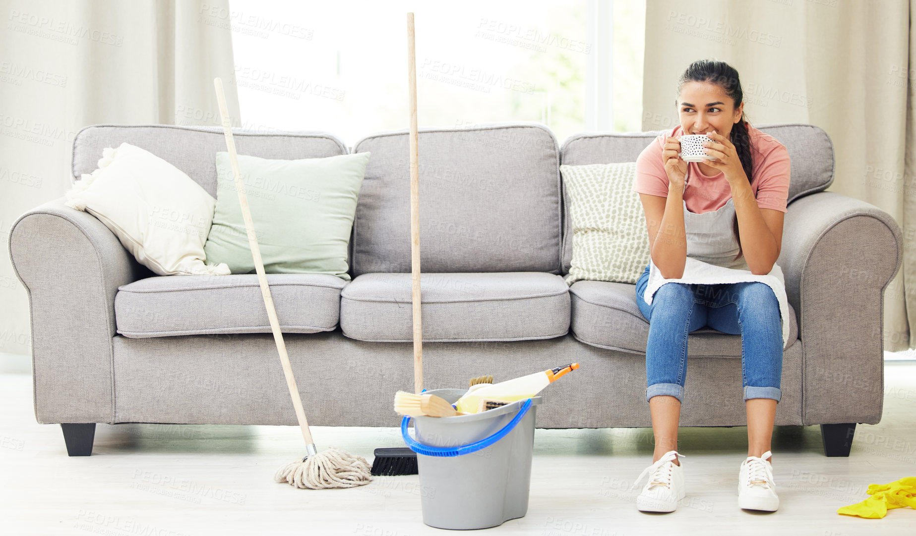 Buy stock photo Shot of a woman taking a coffee break while cleaning at home