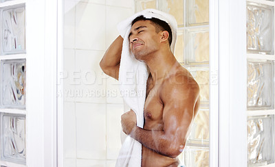 Buy stock photo Shot of a man drying himself after taking a shower