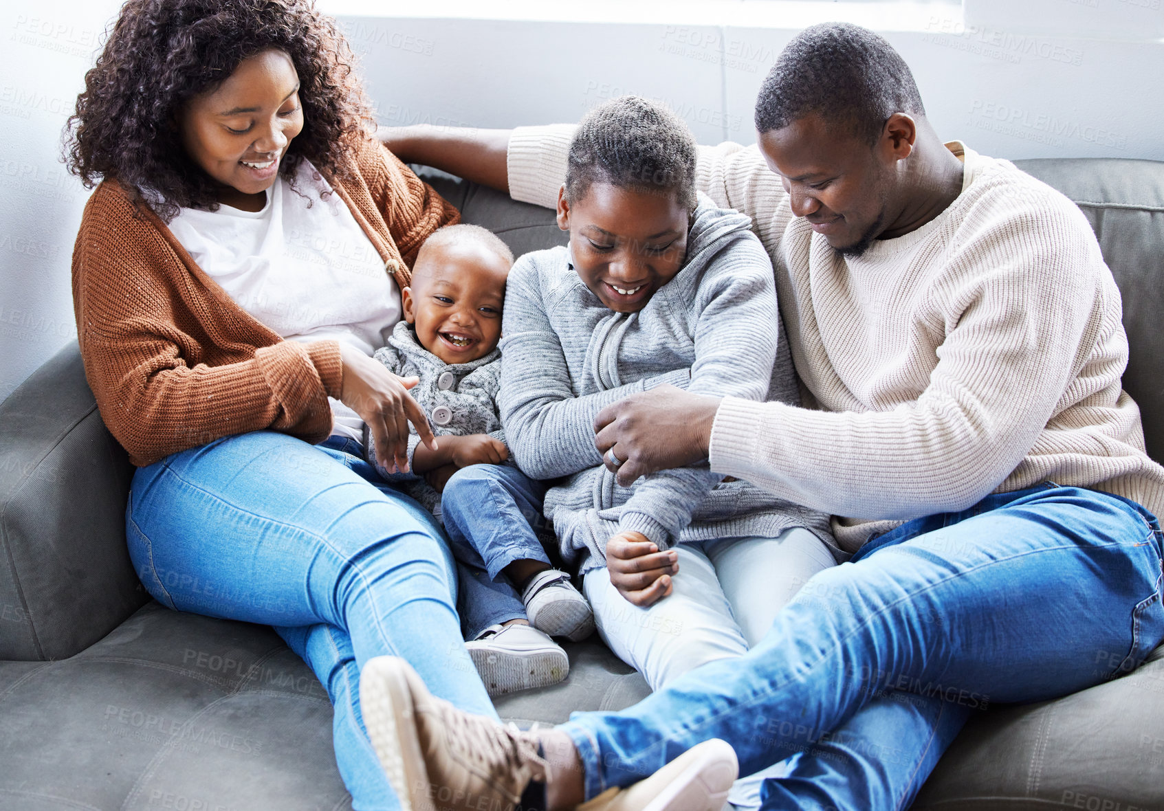 Buy stock photo Shot of a family playing together on the couch in the lounge at home