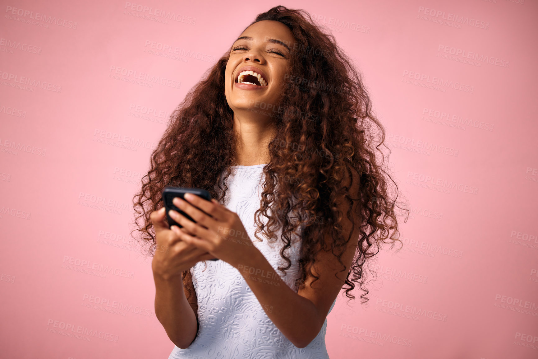 Buy stock photo Happy woman, laughing and funny joke with phone in social media, communication or chat on a pink studio background. Female person with smile in laughter for meme, humor or comedy on mobile smartphone