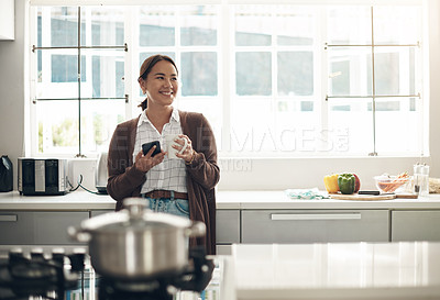 Buy stock photo Thinking, Asian woman or coffee to relax, phone or browse on social media, website or app in kitchen. Gen z girl, happy or smartphone to drink, update or post of meme to connect at weekend of leisure