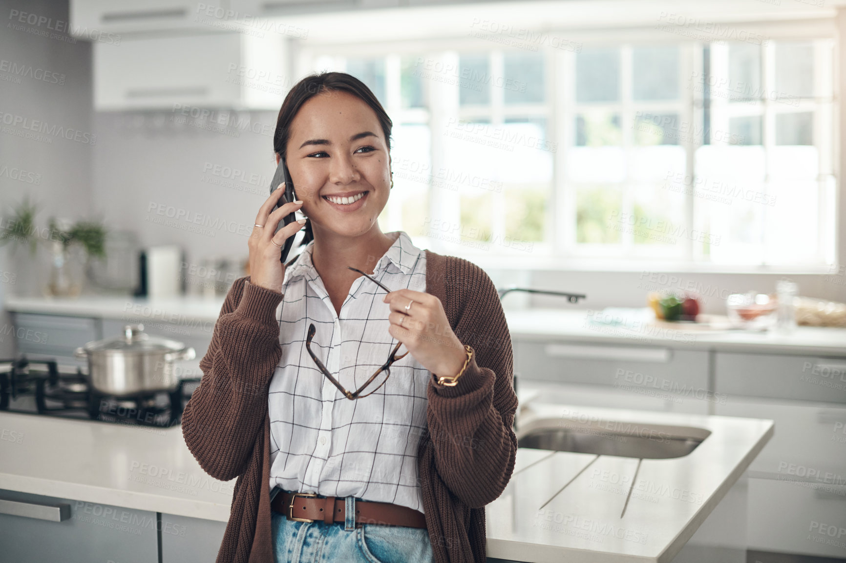 Buy stock photo Asian, happy woman or phone call in a house talking or speaking in kitchen for communication. Chat, mobile or Japanese female person with smile in conversation to relax in home or apartment on break