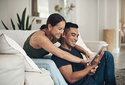 Buy stock photo Couple, house and happy with tablet for search on sofa with pointing for decision for buying. Online shopping, furniture and tech with thinking for choice with positivity, togetherness and bonding