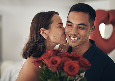 Buy stock photo Love, flowers and valentines day with a couple kissing in their home, in celebration of romance. Dating, rose bouquet or surprise with a man and woman in a house to kiss while bonding in intimacy