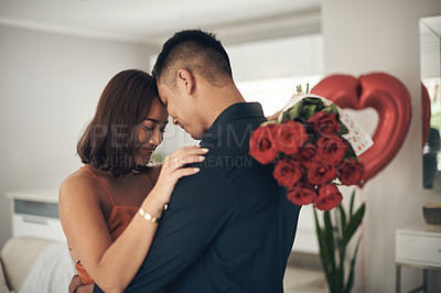Buy stock photo Love, roses and valentines day with a couple hugging in their home, in celebration of romance. Dating, flowering boquet or surprise with a man and woman in a house to hug while bonding in intimacy