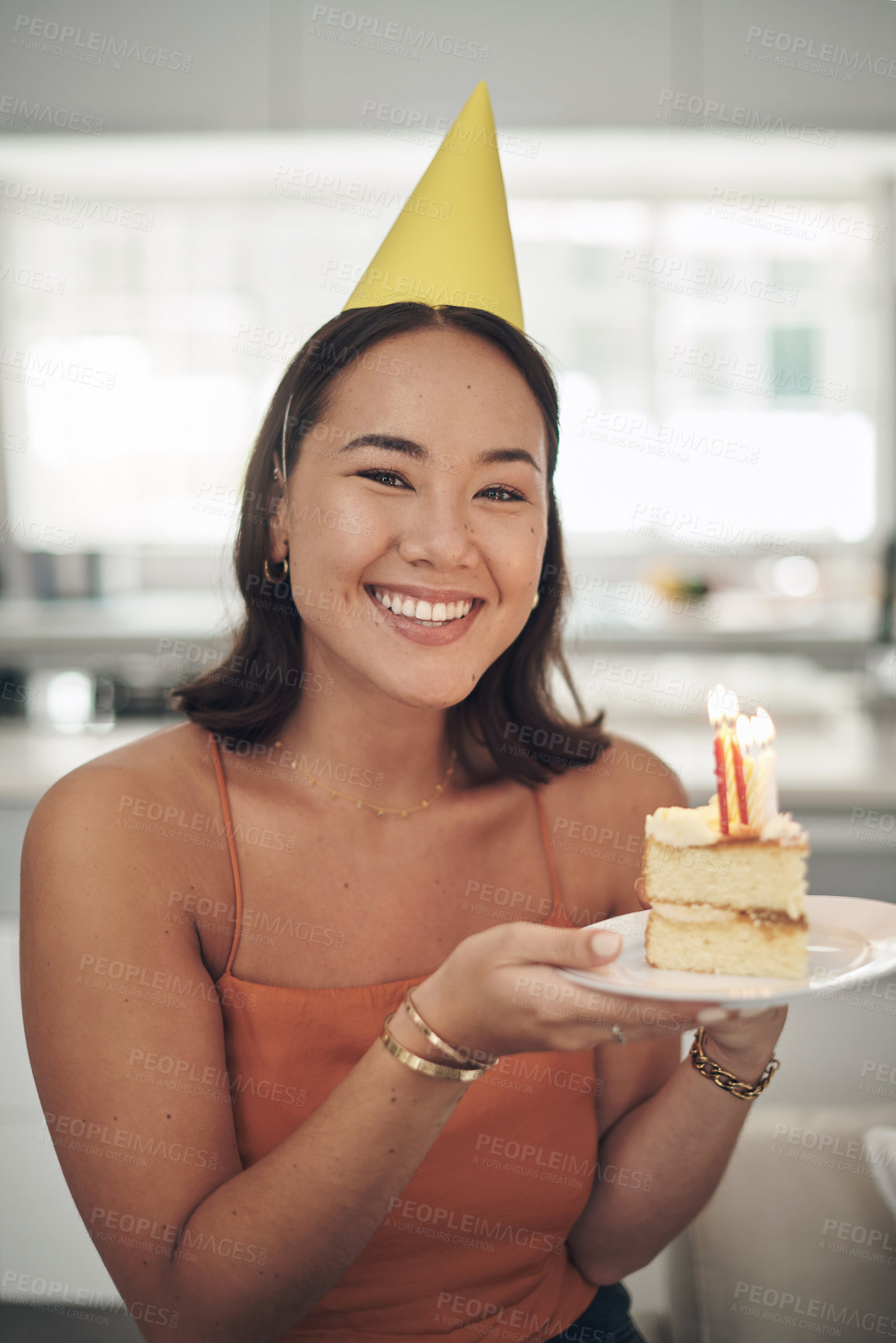 Buy stock photo Birthday, portrait and woman with a cake and party hat for a celebration in the living room of her home. Happy, smile and excited Asian female holding a dessert with candles to celebrate in a house.