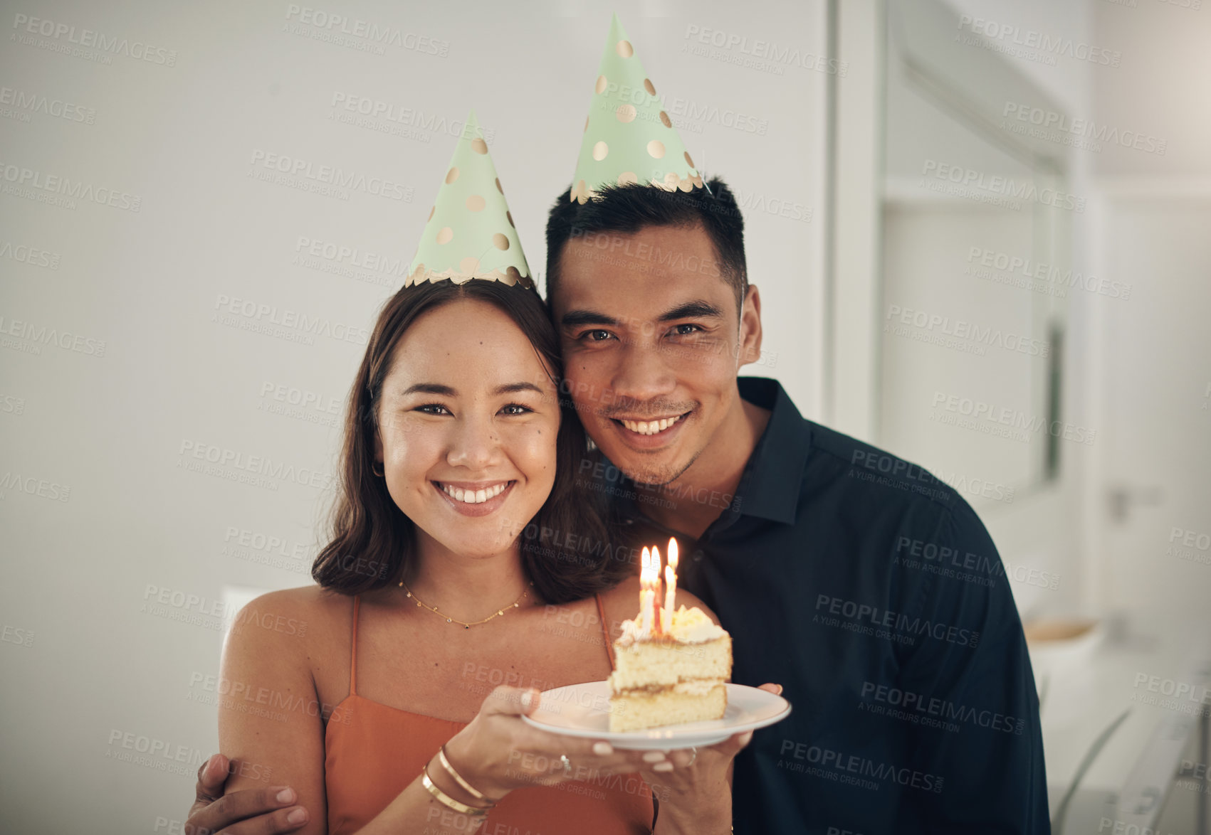 Buy stock photo Portrait, birthday cake and happy with a couple in their home, holding dessert for celebration in party hats. Love, candle or romance with a young man and woman celebrating together in their house