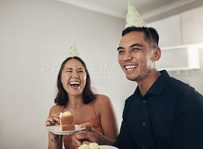 Buy stock photo Love, couple eating cake and birthday party with smile, loving and celebration for achievement and joyful. Romantic, man and woman with hats, dessert and laughing together in living room and cheerful