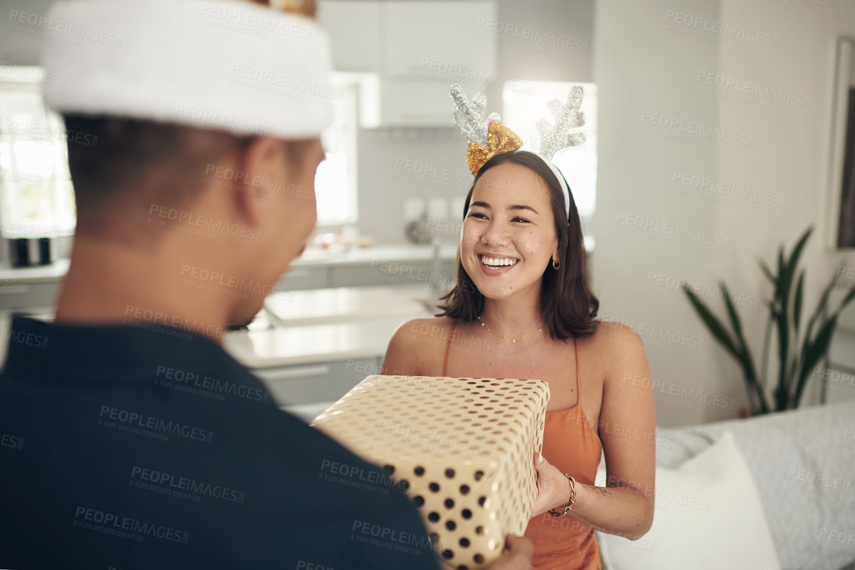 Buy stock photo Woman, couple and christmas gift for celebration in home  with happy partner. Asian girl, festive present and surprise box to celebrate love, care and excited holidays in house, happiness or together